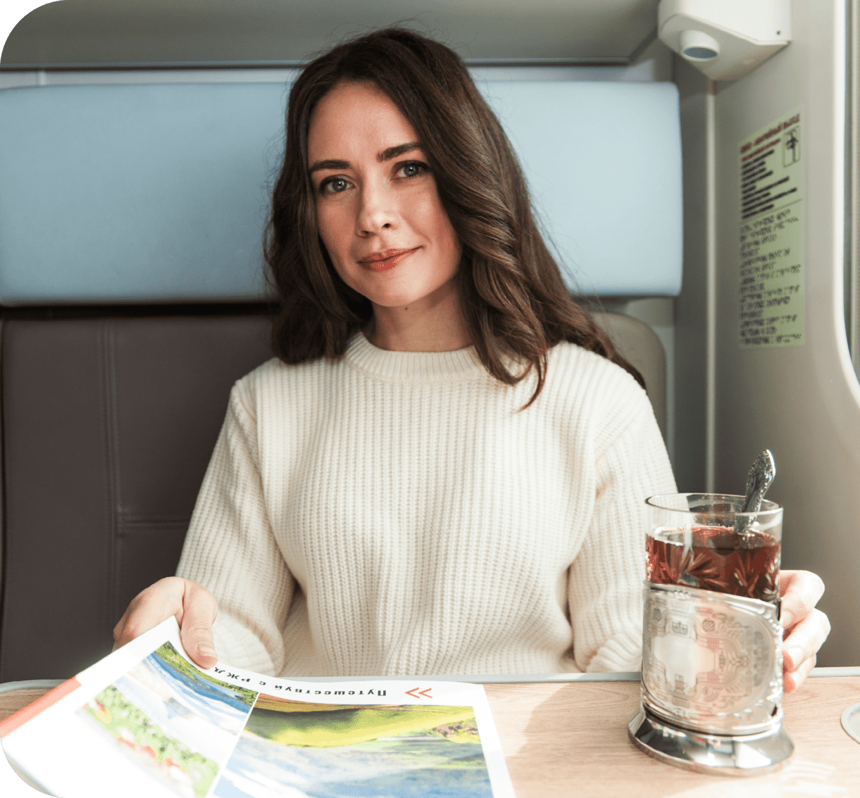 Девушка в купе с кружкой чая и журналом